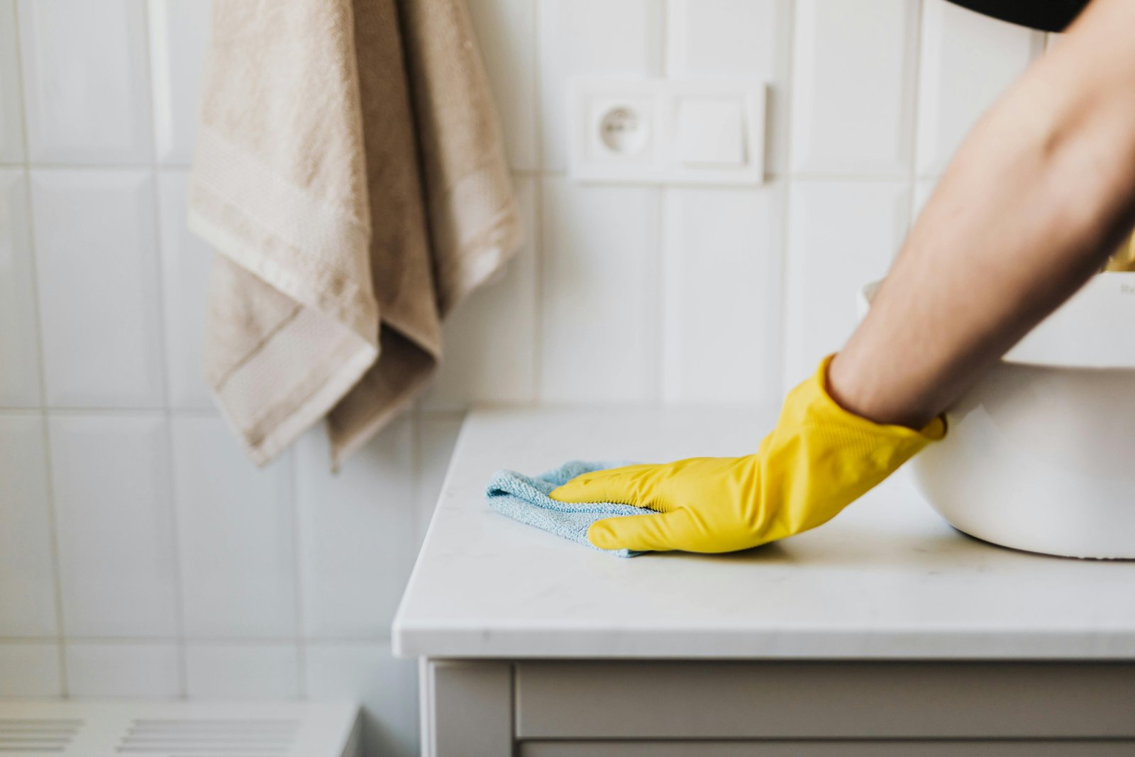Professional cleaner wiping down surfaces with cleaning supplies