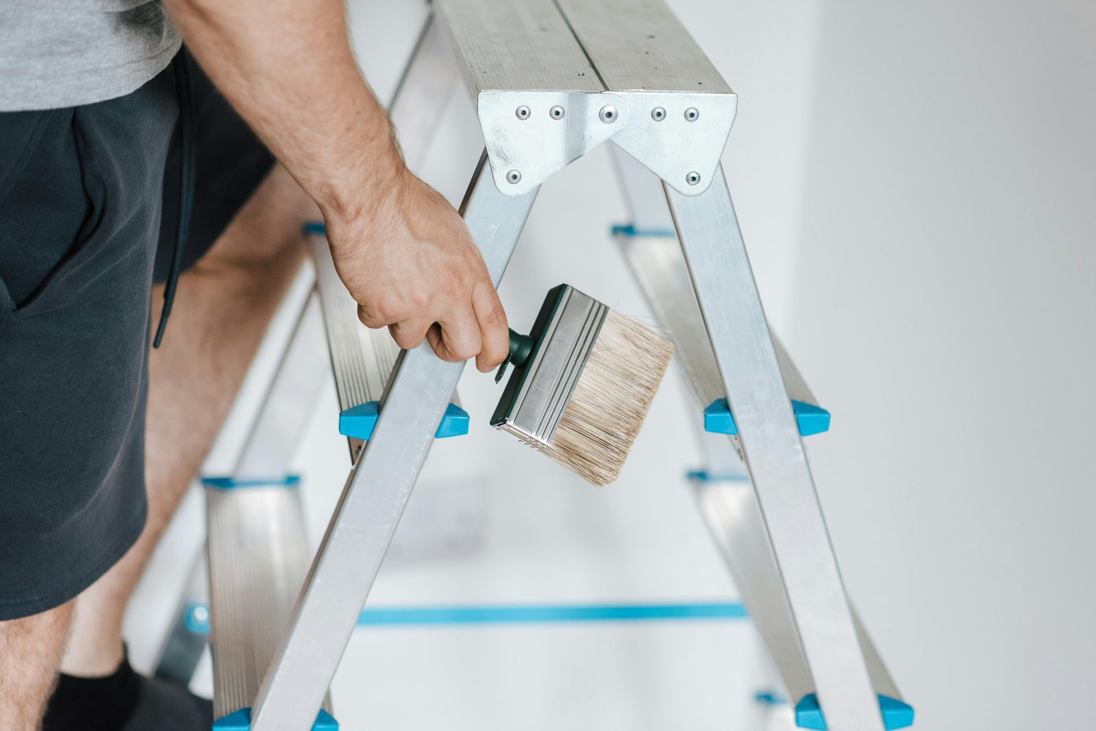 Painter applying fresh coat of paint to a living room wall